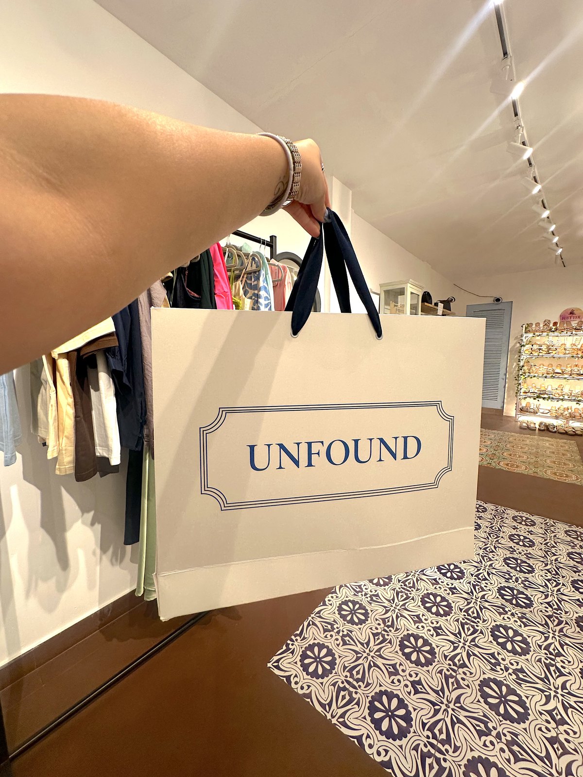 A friend of Unfound holding up an Unfound shopping bag inside the store