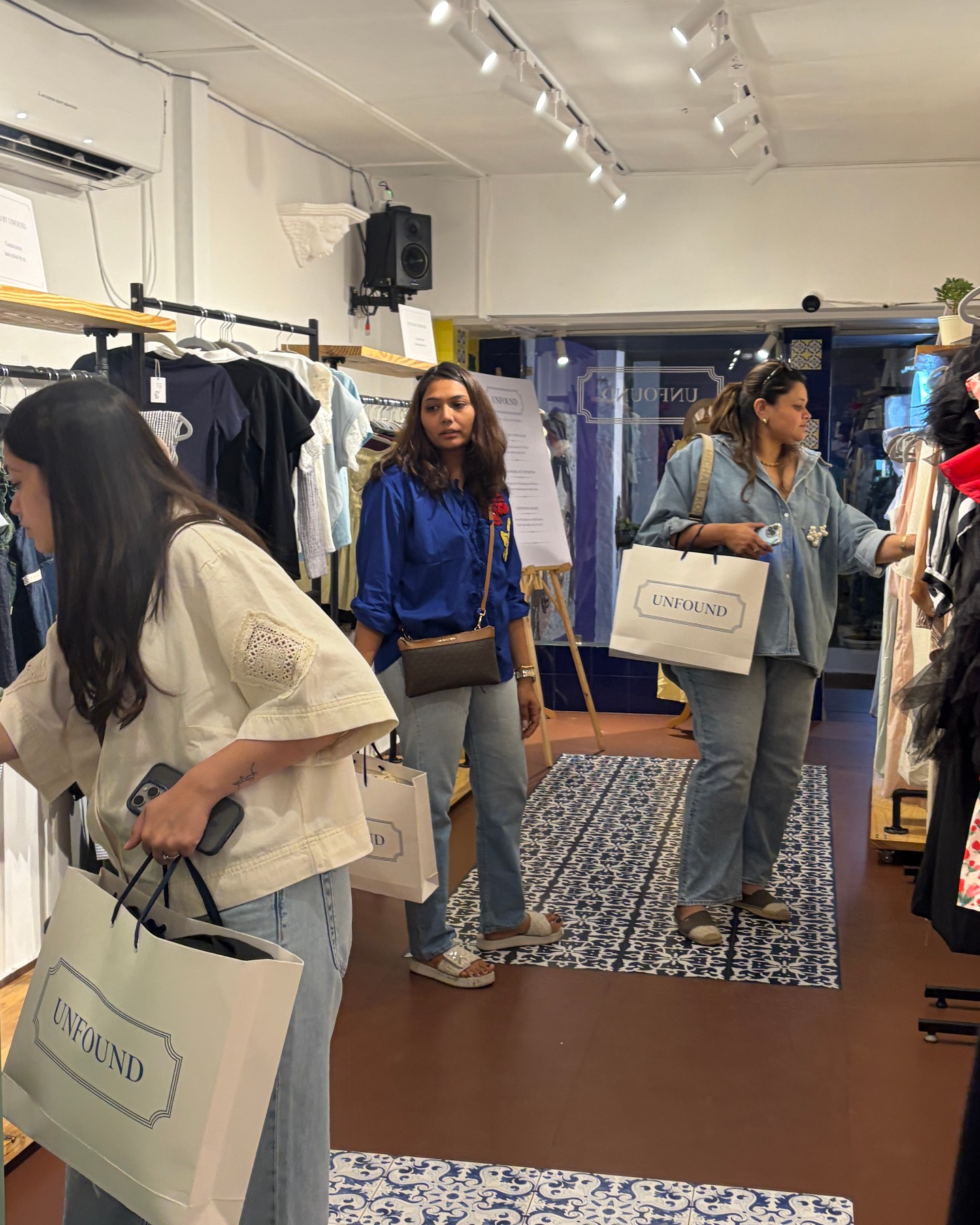 Inside Unfound — shoppers with Unfound bags among the racks